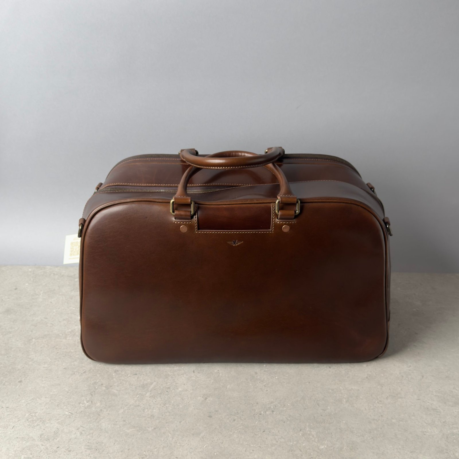 Satchel & Page leather weekender bag in brown on a neutral background