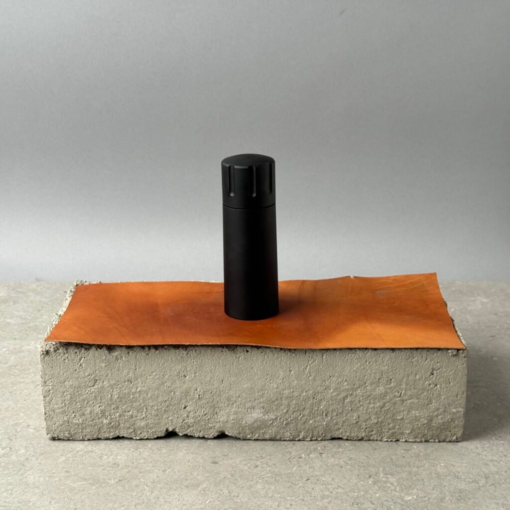 Mannkitchen Pepper Cannon manual pepper grinder in black on leather surface