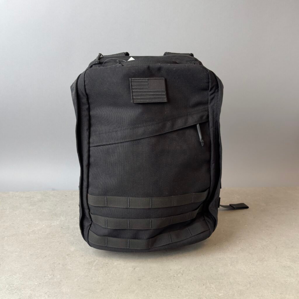 GORUCK GR1 black backpack front view with MOLLE webbing and American flag patch, durable tactical everyday carry backpack