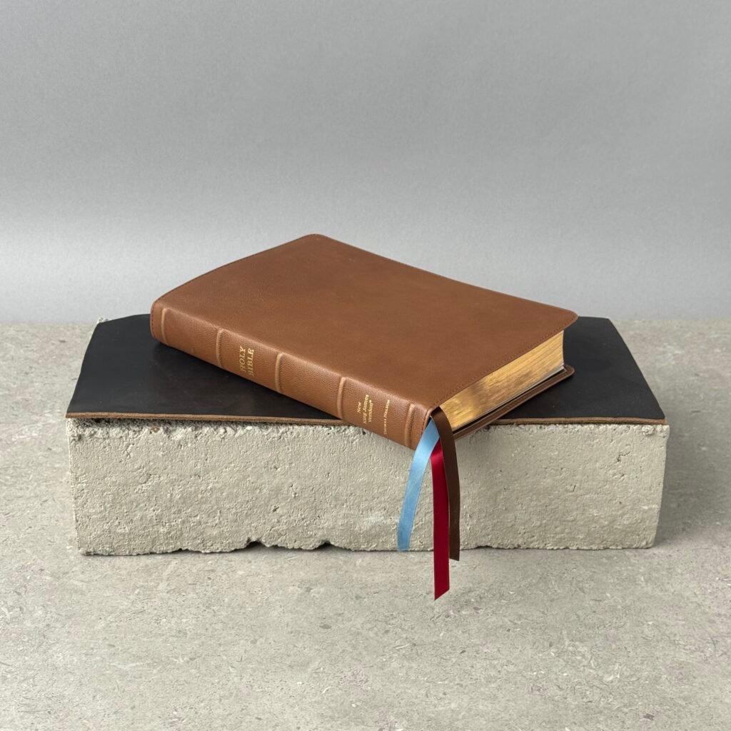 Thomas Nelson goatskin leather Bible in brown with gold page edges and ribbon bookmarks on minimalist display